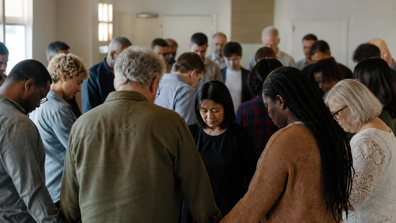 Cristãos de diferentes etnias e idades reunidos em oração, representando a unidade da Igreja global.